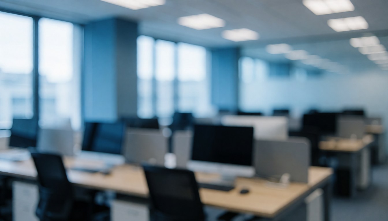 Modern corporate office featuring desks, computers, and windows with blue and gray tones suitable for accounting and finance