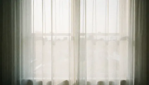Bright window with translucent curtains providing a soft, airy background for professional human resources text.