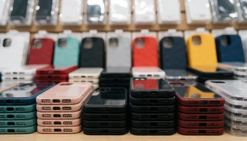 Blurred background of colorful phone cases on a shelf, ideal for technology store advertisements