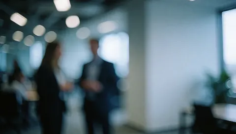 Blurred corporate office background with cool tones and soft lights, providing ample space for text overlay