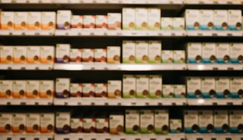 Warm toned blurred background of retail shelves stocked with nutrition supplements, providing copy space for business text