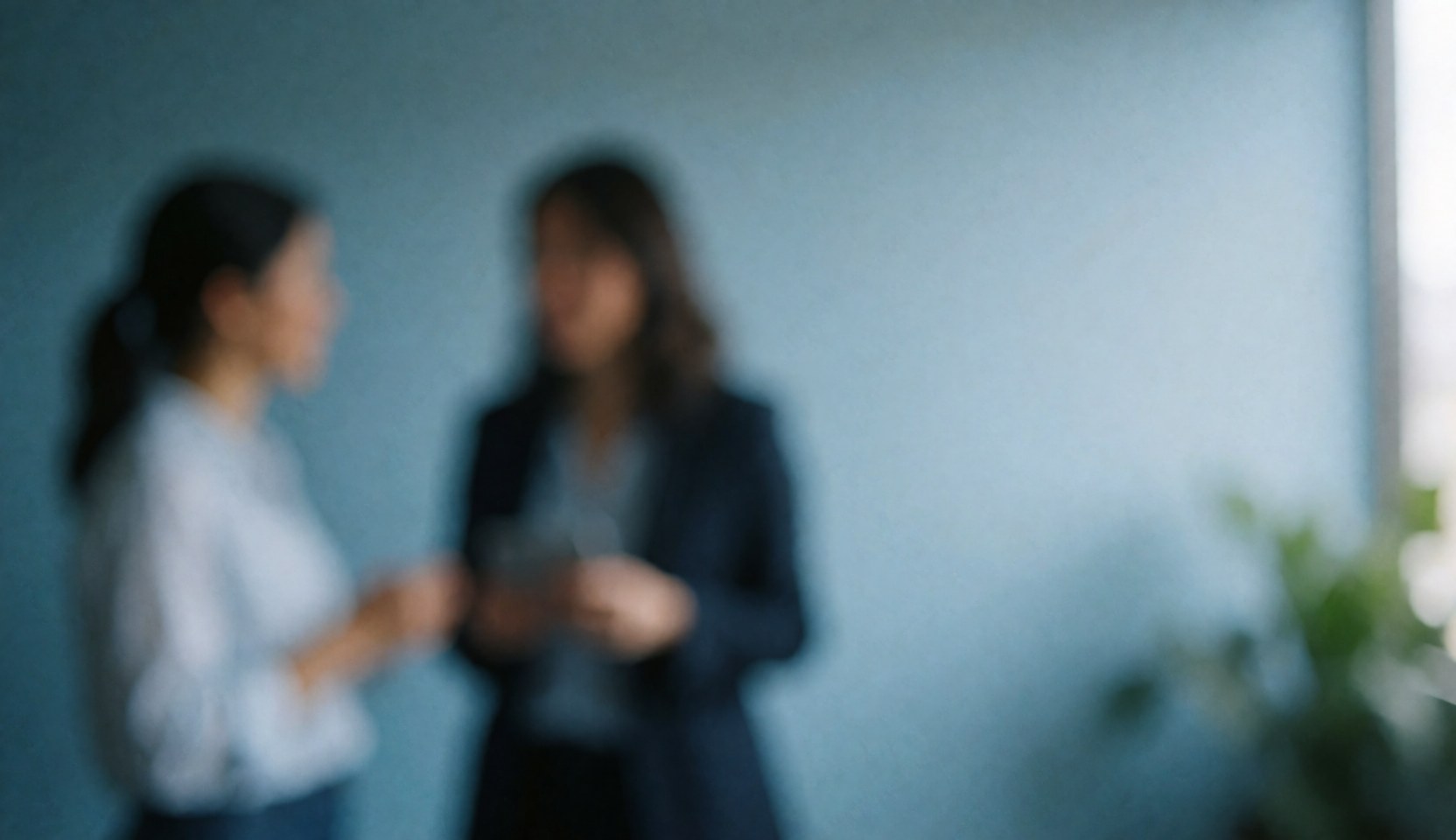 Blue-toned office background with two blurred people conversing and ample copy space on the right for financial text