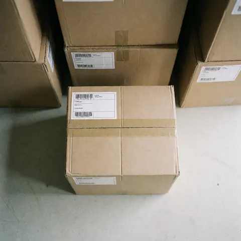 Sealed and labeled moving box ready for transport in a warehouse with stacked boxes, ideal for moving and logistics services