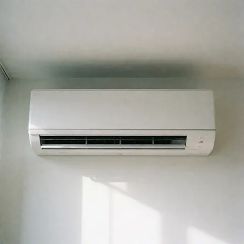 Modern white wall-mounted air conditioning unit with soft shadows and natural light, suitable for commercial HVAC applications