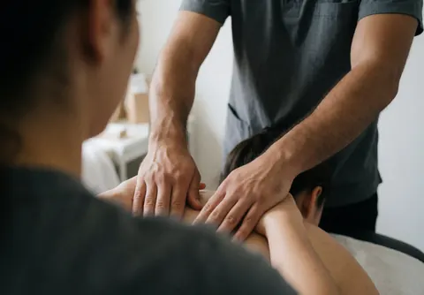 A beautician performs a relaxing facial massage on a female client in a professional salon setting