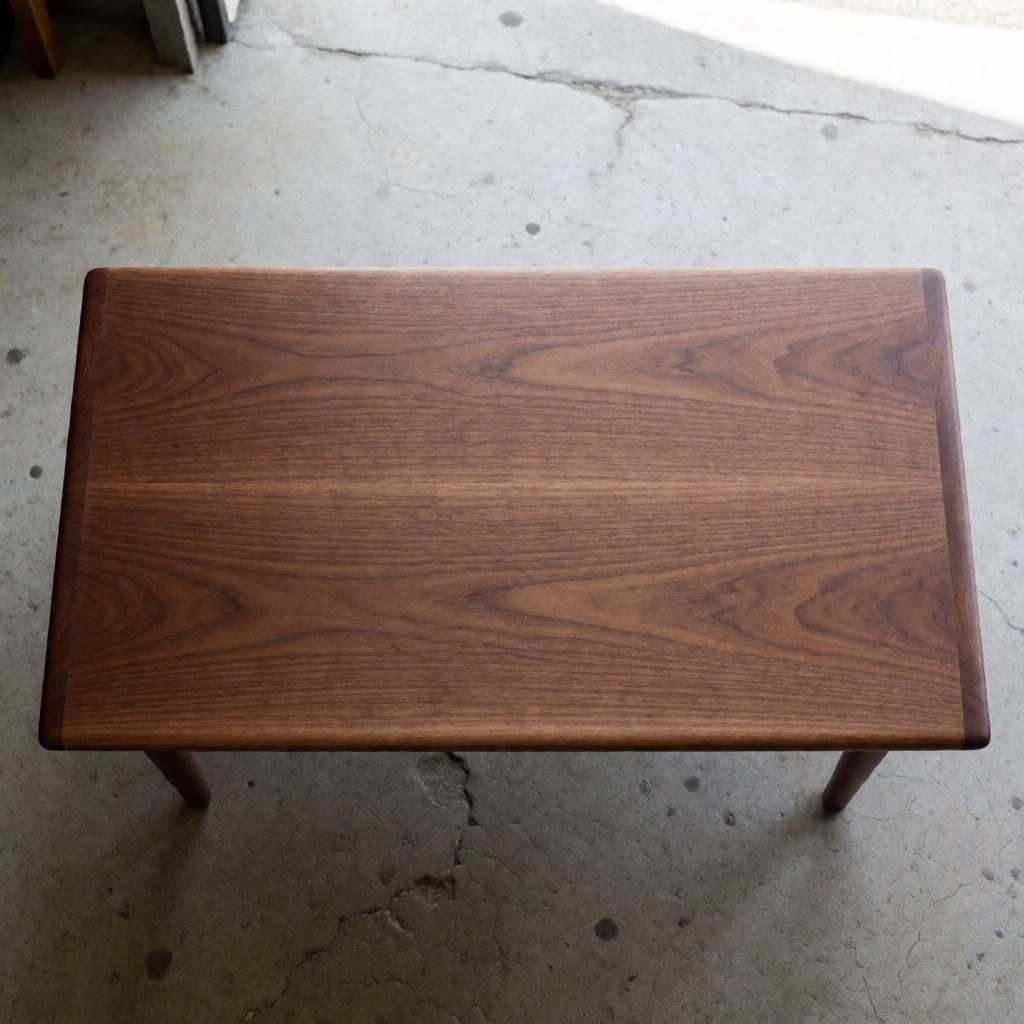 Solid wood table with polished finish, on cracked concrete floor.