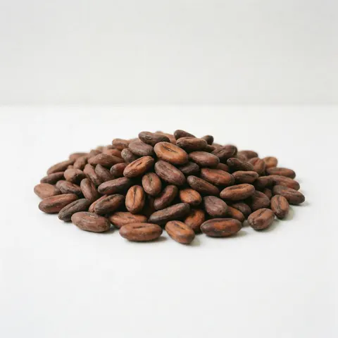 A pile of roasted cocoa beans on a white background, natural product for cafés and gourmet items.