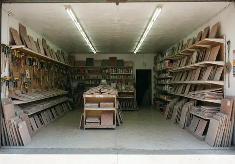 Construction materials warehouse with shelves full of planks, tools and DIY products.