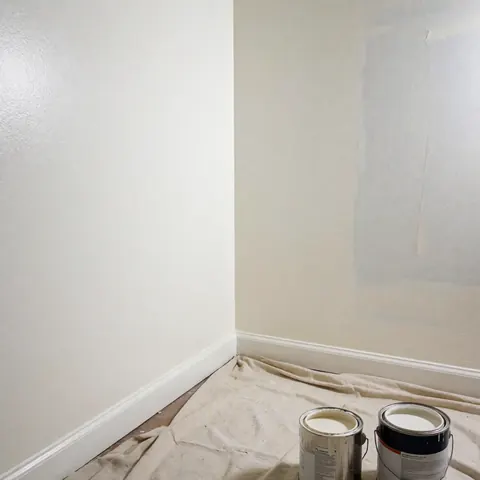 Interior wall freshly painted with canvas and paint cans showing professional and clean finish