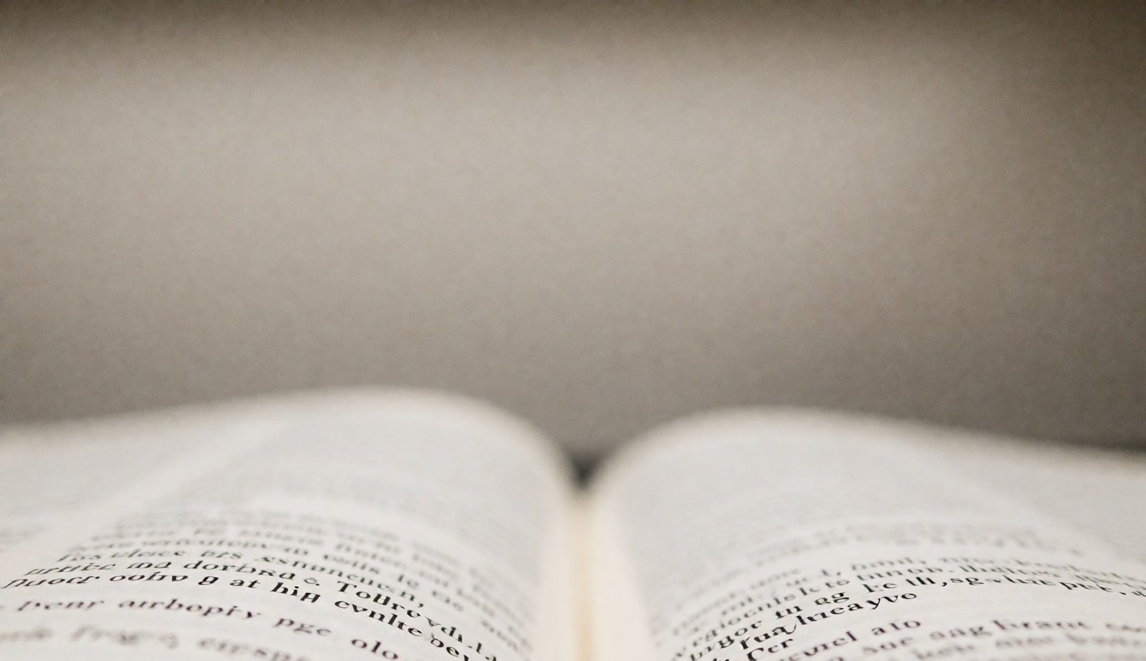 An open book page with blurry text, ideal for representing reading, studying, or educational content.