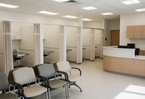 Clean veterinary clinic interior featuring exam rooms, waiting chairs, and a reception desk ready for patients and owners