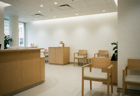 Modern reception with wooden desk and waiting chairs for clients.
