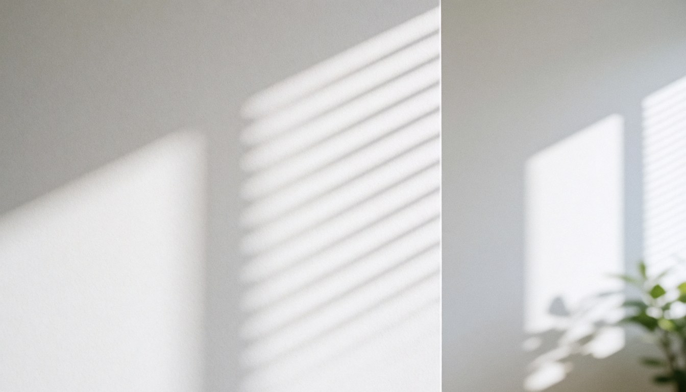 A white wall illuminated by natural light with distinct shadows from window blinds, creating a clean and professional atmosphere suitable for a law firm office background.