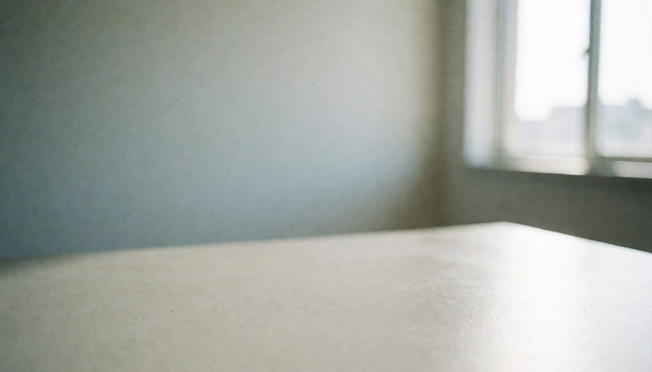 Minimalist white table surface against a wall and window, providing a clean backdrop for business presentations and training materials.