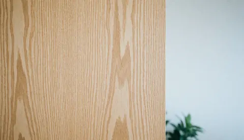 Close-up of natural wood grain with a soft texture and ample white space on the right side for text or logos