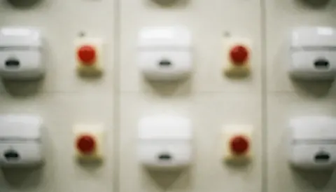 Abstract red security buttons and white alarm icons on a clean background, ideal for business text overlays
