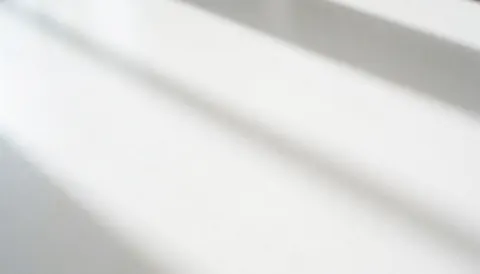 Clean white table surface with soft shadows, ideal for placing products or text for modern businesses