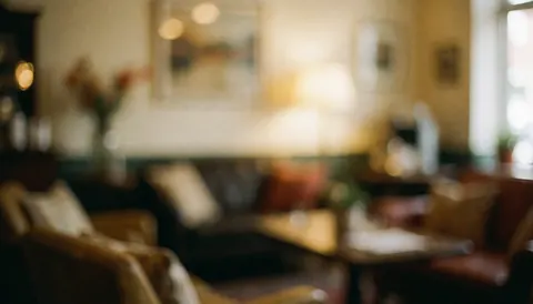Soft focus warm cafe interior with cozy furniture and ambient lighting, perfect for business text overlays.