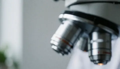 Abstract background of microscope lenses in a clinical lab with gray and white tones, soft light, and minimalist design for health and science websites