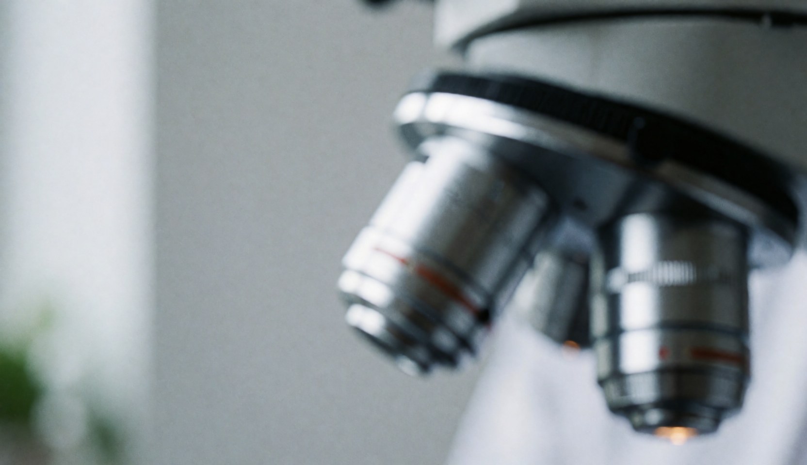 Abstract background of microscope lenses in a clinical lab with gray and white tones, soft light, and minimalist design for health and science websites