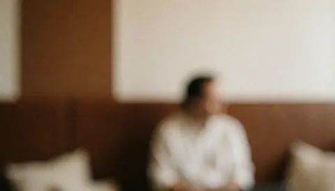 A blurred image of a coffee bar interior featuring wooden walls, chairs with cushions, and natural lighting, suitable for a cozy coworking space background.