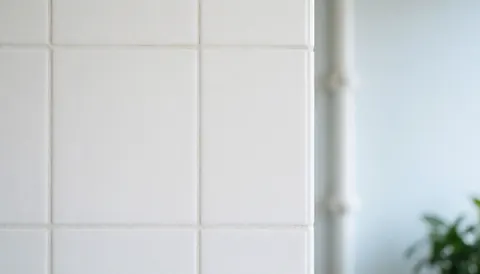 Clean white tile wall with grout lines, ideal for any business.