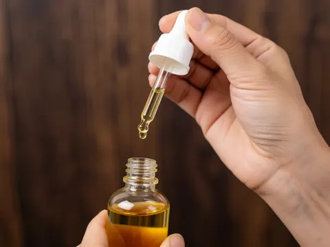 A single drop of argan oil resting on a hand, highlighting natural hair treatment and beauty care for salon services