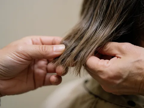 Detailed view of smooth, shiny brown hair strands showing healthy texture and natural shine, highlighting the results of professional hair care and styling services.