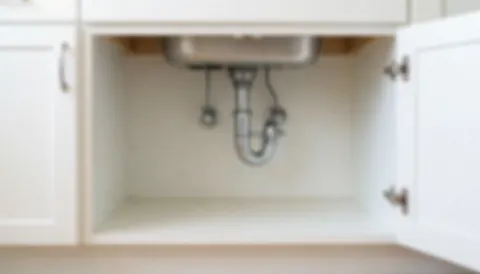 A clean, blurred white cabinet under a sink, providing a professional and organized background for business text and teamwork themes.