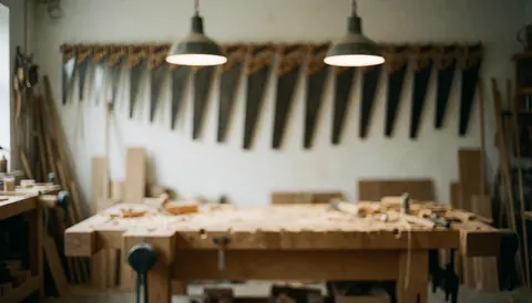 Blurred workshop background featuring carpentry tools, saws, and wood textures on a workbench with industrial lighting