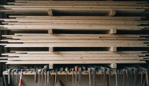 A blurred workshop background featuring various tools and materials such as wood, ropes, nails, hammers, and paint, ideal for entrepreneur business contexts