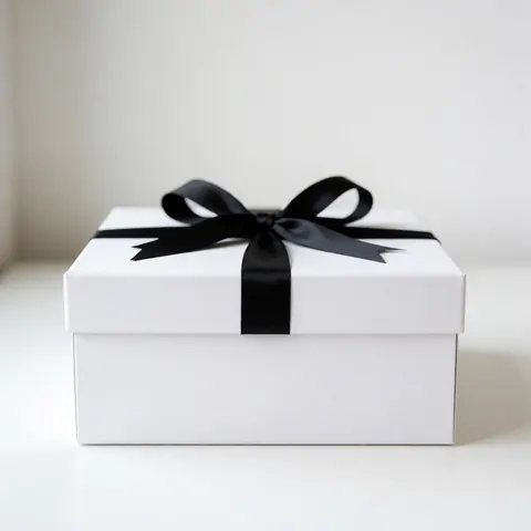 A closed white gift box tied with a black ribbon, presented against a clean background for corporate gifting and product display purposes