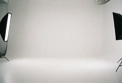 Clean white studio space with professional lighting equipment, ideal for business portraits and corporate photography.