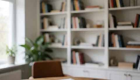 White bookshelf with books, plant, and window, ideal for corporate text and remote work services