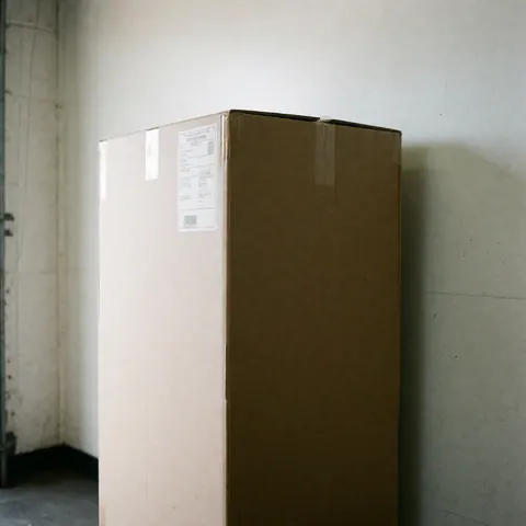 Cardboard box with label and barcode ready for transport in a warehouse with white walls and natural light