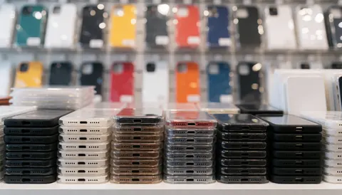 Vibrant smartphone cases and screen protectors arranged on a retail store shelf, providing a colorful background for commercial text and promotions.