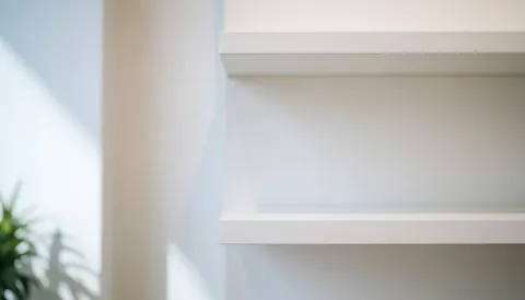 A clean, minimalist white shelving unit against a white background, ideal for showcasing electronics, phones, and digital products in a professional commercial setting.