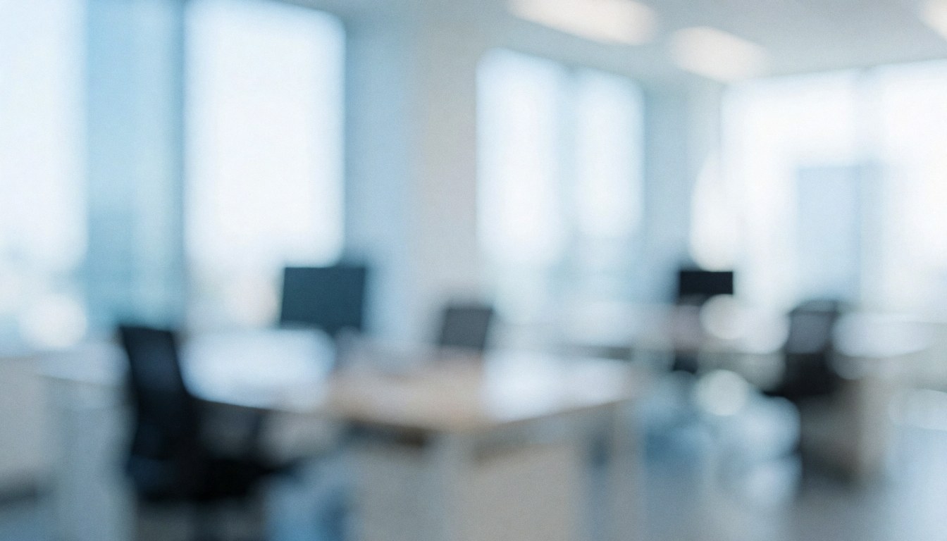 A blurred modern office interior featuring white walls, blue accents, and natural light from windows, ideal for business and human resources text backgrounds.
