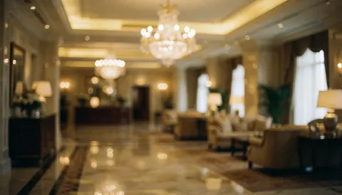 Elegant hotel lobby featuring marble flooring, warm lights, sofas, and chandeliers, creating a professional atmosphere for corporate text backgrounds.