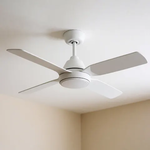 A sleek white ceiling fan mounted on a white ceiling above a beige wall, providing clean and calm modern home decor in a well-lit room.