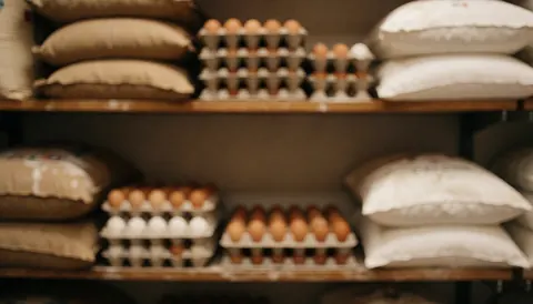 A warm textured background of a pantry featuring stacked flour sacks, eggs, and wooden shelves, ideal for entrepreneur business content