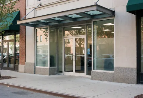Modern security business storefront featuring reinforced glass doors, a sleek awning, and a clean sidewalk facade.