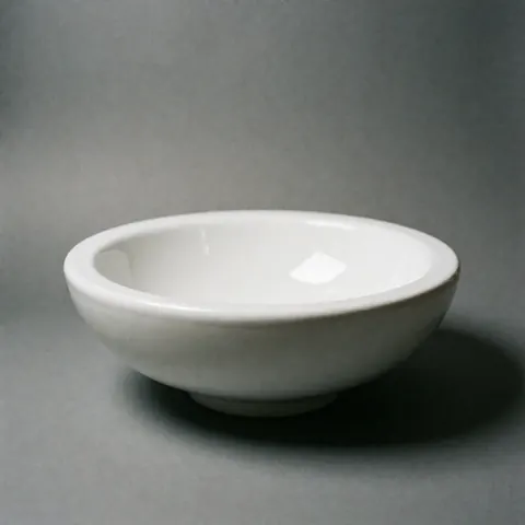 White ceramic sink on gray background with soft minimalist lighting, ideal for bathroom or kitchen decor