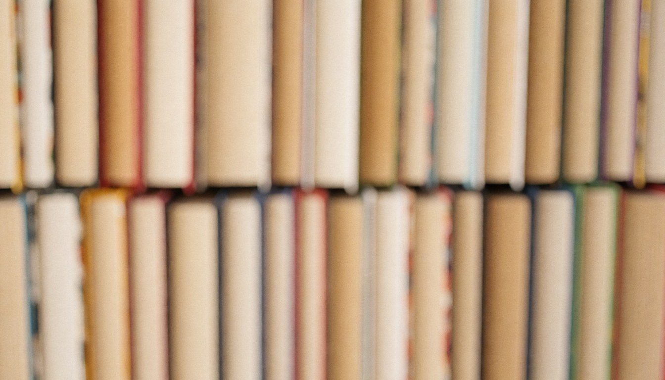 A blurred background of stacked books in various colors and genres, suitable for a bookstore website text overlay.