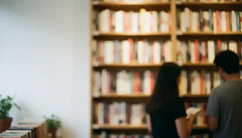 Soft focus background of a bookstore interior featuring wooden bookshelves filled with books, creating a calm atmosphere suitable for text overlay