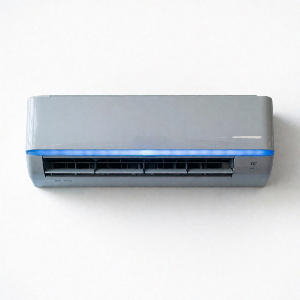 Close-up view of a sleek white indoor air conditioning unit mounted on a plain wall, showcasing its minimalist design and clean lines suitable for residential or commercial HVAC installations.