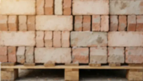 A close-up view of a textured construction site background featuring bricks, cement, and building materials suitable for text overlay in business contexts