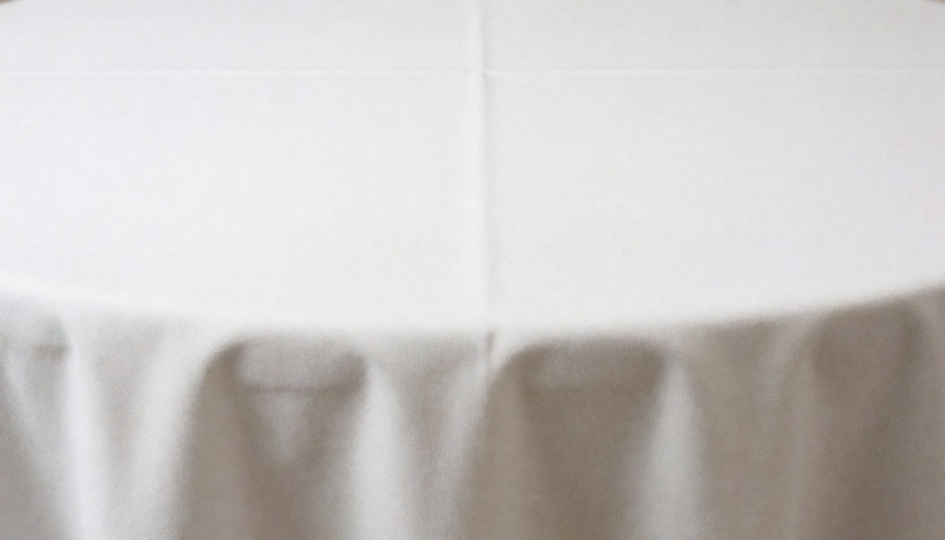 A clean, minimalist white tablecloth surface serving as an elegant background for text, suitable for weddings and corporate events.