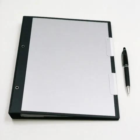 Professional sales folder with a black pen placed on a clean white surface, suitable for business presentations and agreements.