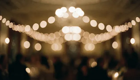 Soft romantic bokeh background with warm lights suitable for wedding invitations and event text overlays